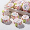Detail of DIY cake-shaped beads with pink bows and iridescent pearls for jewelry making - Pink White Cream with Pink Bow and Green X