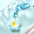 Close-up of blue gradient frangipani keychain with matching blue metal hardware and D-ring - Blue