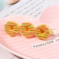 Close-up of hair clips with three resin donuts on a pink heart-shaped ceramic plate - Matcha Donut