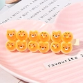 Macro view of cute orange resin hair clip with cartoon bears and chicks on pink tray - Cartoon Bun