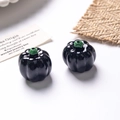 Vista macro di perle a forma di zucca nera fluorescente con stelo verde per gioielli fai da te - Stile A / Nero