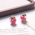Detailed view of clear glass ball charms filled with pink heart sequins for DIY jewelry - Red