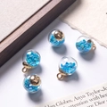 Blue heart sequin floating sand in clear glass ball pendant with gold loop - Sky Blue