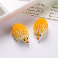 Vista macro de dos mini erizos de resina amarilla para decoración de micro paisajes - Naranja