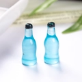 Macro-opname van twee miniatuur blauwe hars frisdrankflessen voor een poppenhuis - Blauw