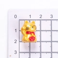 Macro view of mini golden resin fortune cat figurine with 1.5cm measurement scale - Single Piece / Gold (Right Hand Raised)
