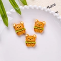 Three cute orange resin bear biscuit charms displayed on a decorative white porcelain plate - Bear Vegetable Biscuit Style