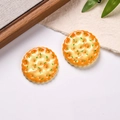Macro shot of two realistic resin biscuit charms with green scallion flakes on white fabric - Sold by Piece / Scallion Flavor Biscuit