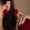 Dettaglio di modella che indossa orecchini a rosa di velluto con perle rosso scuro - Stile con Perline Rosse (E7953)