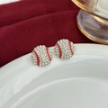 Macro shot of baseball stud earrings with white rhinestones and red enamel stitching details - Rhinestone Baseball Style