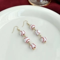 Detail of baseball theme drop earrings featuring white beads with red stitching patterns - Beaded Baseball Drop Style