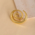 Elegante spilla a spirale dorata in metallo lucido su uno sfondo di pietra materica - Oro