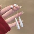 Dettaglio di lunghi orecchini a catena dorata con perle a goccia bianche smerigliate - Nappina Fiocco di Neve Oro (E1032-2)