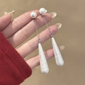 Dettaglio di lunghi orecchini a goccia con pendenti bianchi testurizzati e catena argento - Nappina Fiocco di Neve Argento (E1616-3)