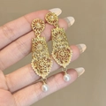 Dettaglio di orecchini vintage dorati con perle su uno sfondo a tinta unita - Stile Perla Artificiale Boho (E5136)