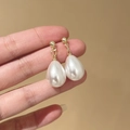 Dettaglio di orecchini a goccia dorati con perle bianche a forma di goccia - Oro (E2081-3)