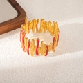 Dettaglio del bracciale dorato stile lava con accenti di onde in smalto rosso acceso - Motivo a Onde Rosse (S984)