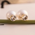 Elegant double-sided pearl earrings with gold-claw cubic zirconia on a natural green branch - White