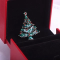 Détail macro d'une broche sapin de Noël en émail et strass dans un coffret cadeau rouge - Sapin de Noël Style 2 (Z54)