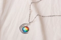 Macro shot of silver crescent moon necklace with colorful cosmic nebula sphere detail - Rainbow Gradient Nebula Pattern (X629-5)