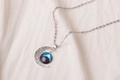 Detailed view of the hollowed-out crescent moon pendant with blue galaxy glass orb - Blue-Black Galaxy Pattern (X629-11)