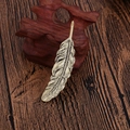 Spilla piuma dorata vintage con trama di foglie su una base di legno classica - Bronzo Antico