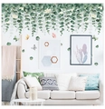 Detail von hängenden Eukalyptus-Wandstickern mit Schmetterlingen im modernen Wohnzimmer - Grün