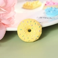Macro view of a yellow resin donut pendant with colorful sprinkles and a central hole - Extra Large / Yellow