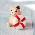 Macro view of khaki resin bear charm with a red lifebuoy and top metal hanging ring - Red Lifebuoy