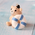 Macro shot of a resin brown bear charm with blue life buoy and silver metal ring accessory - Blue Lifebuoy