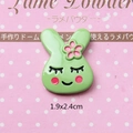 Macro shot of a 1.9x2.4cm green resin rabbit charm with a pink flower for DIY crafts - Squinting Rabbit-Green