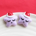 Macro de deux étoiles de Noël en résine violette avec bonnets de Noël sur plateau blanc - Mauve Clair