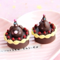 Dettaglio di mini torte a forma di maialino di cioccolato con cappelli su un piatto rosa - Nota La Dimensione È Grande Come Il Lychee / Marrone