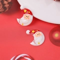 Flat lay of Christmas moon Santa Claus resin charms on a festive red background decoration - Moon Santa