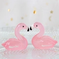 Close-up of pink luminous resin swan ornaments on a glass plate with starry fabric - 2.7x2.8cm / Pink