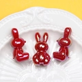 Detailed close-up of dark red luminous bunny beads on a white embossed ceramic tray - 3mm Hole / Red