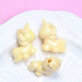 Détail de perles licorne nacrées pour bracelets DIY sur un fond de couleur rose - Trou 3mm / Jaune