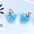 Macro view of heart-shaped glass pendants with light blue star sequins and gold loops - 1.8 x 2.4cm / Sky Blue