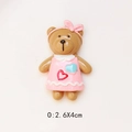 Detailed view of a brown resin bear DIY charm wearing a pink dress, size 2.6x4cm - Pink Headband Pink Skirt
