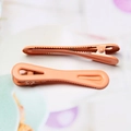 Detailopname van twee koraaloranje holle metalen haarklemmen met gekartelde randen - 1.3x6.1cm Hoge Kwaliteit / Oranje