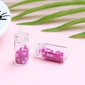 Détail de mini bouteilles à vœux en verre avec paillettes roses pour bijoux DIY - Rose rouge