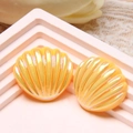 Macro view of yellow iridescent scallop resin charms for DIY hair clips and jewelry - Yellow