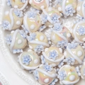 Macro detail of creamy acrylic beads with blue floral relief and rainbow luster finish - 18mm / Off-white Bead + Gradient Blue Plum