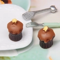 Macro shot of miniature chocolate cupcakes with star decorations and tiny metal cutlery - Coffee