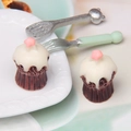 Macro shot of miniature simulation cupcakes with star topping and tiny cutlery set - White