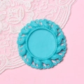Detailed top view of a 2.5cm turquoise floral relief resin base on a pink background - Lake Blue