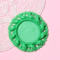 Macro view of a 2.5cm green vintage style round DIY jewelry base with floral relief - Verdant