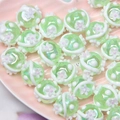 Detailed macro view of mint green floral glass beads for DIY jewelry making - 18mm / Transparent Green Bead + White Flower