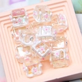 Macro shot of colorful iridescent DIY beads with 3D white floral patterns and rhinestones - 18mm / Transparent Square White Flower + Rhinestone