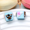 Macro shot of blue square resin beads featuring cartoon bears and Hi text for DIY crafts - Brown Dog / Blue